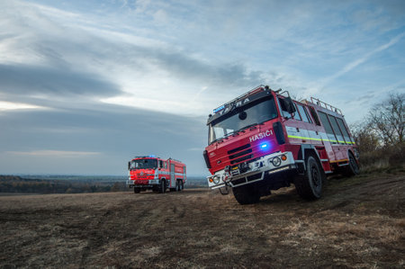 Fire engine in the field at sunset. Firefighters in action.