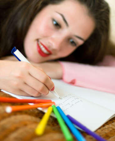 a girl writing a letter on the paperの写真素材
