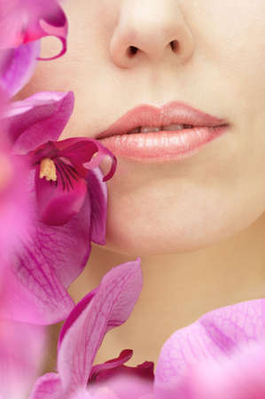 beautiful woman face close-up surraunded by flowersの写真素材