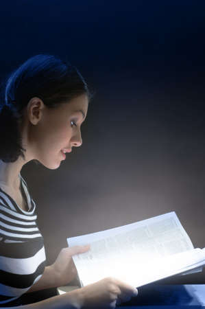 young beautiful girl reading a large bookの写真素材