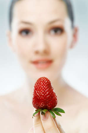 a beauty woman enjoying a fresh strowberryの写真素材