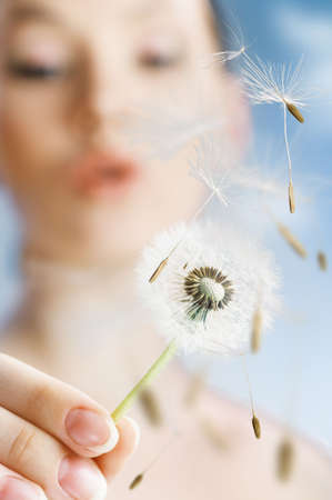 beautiful smiling girl with dandelion in handの写真素材