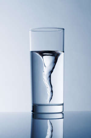 glass with spring water against a blue backgroundの写真素材