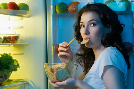 a hungry girl opens the fridgeの写真素材