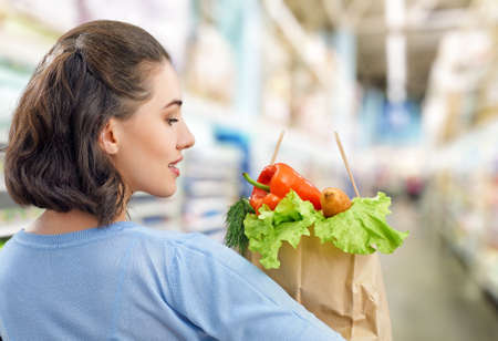 a woman holding a bag of fruit