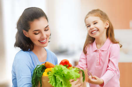 mother and daughter holding fruitの写真素材