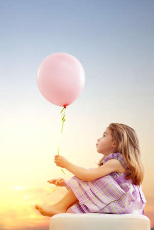 little girl holding pink balloonの写真素材