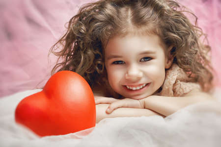 little girl holding a heartの写真素材