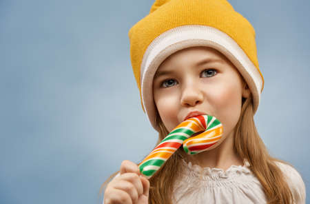 little girl eats a candy barの写真素材