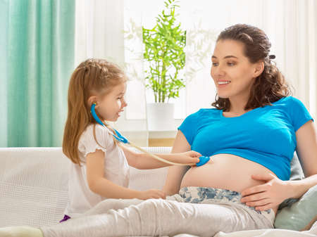 happy pregnant woman with her childの写真素材