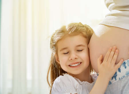 happy pregnant woman with her childの写真素材