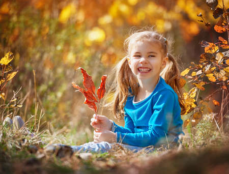 happy little child, baby girl laughing and playing in the autumn on the nature walk outdoors