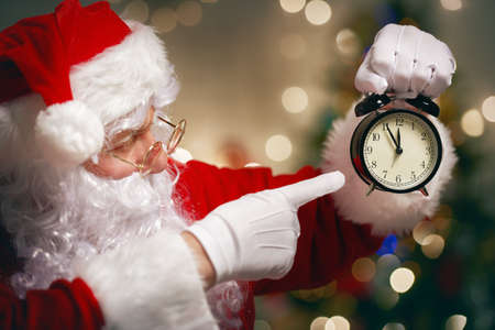 Portrait of Santa Claus with alarm clock in handの写真素材