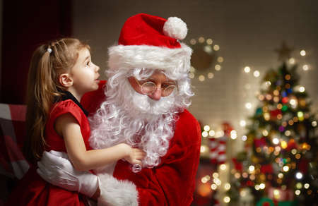 Santa listening to a little girl's wishesの写真素材