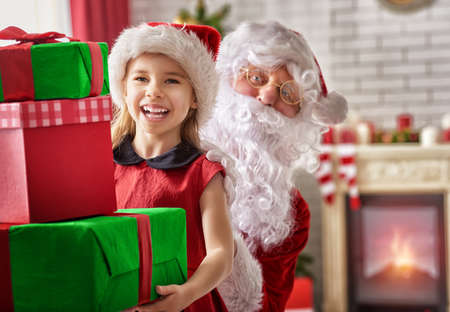 Santa Claus giving a present to a little cute girlの写真素材