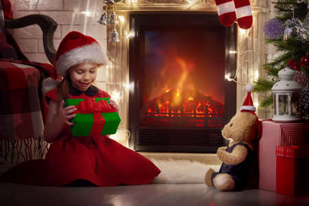 Funny smiling child holding Christmas gift in hand.の写真素材
