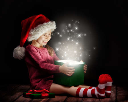 Cute little girl opening a magic gift box.の写真素材