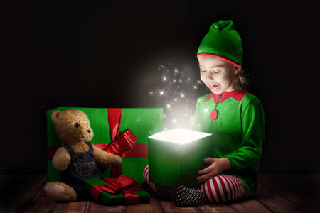 Cute little girl opening a magic gift box.