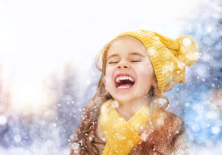 Happy child girl playing on a winter walk in natureの写真素材
