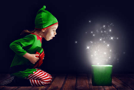 Cute little girl opening a magic gift box.の写真素材