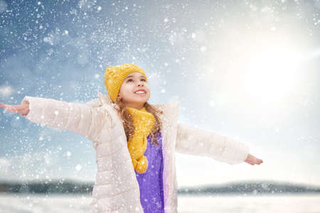 Happy child girl playing on a winter walk in natureの写真素材