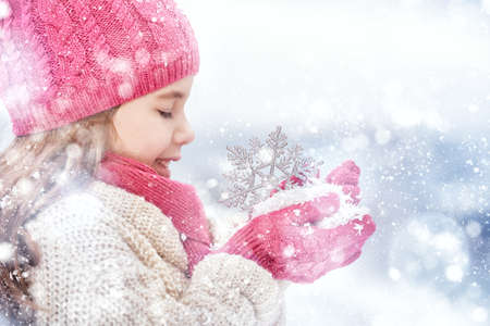 Happy child girl playing on a winter walk in natureの写真素材