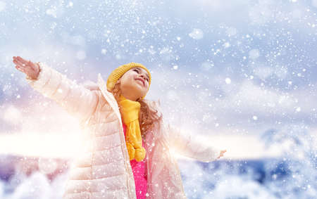 Happy child girl playing on a winter walk in natureの写真素材