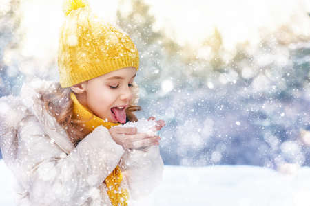 Happy child girl playing on a winter walk in natureの写真素材
