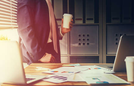 businessman drinking coffee at his workplace in the office. coffee break.の写真素材