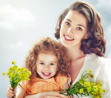 Smiling mother and little child. Happy family outdoors