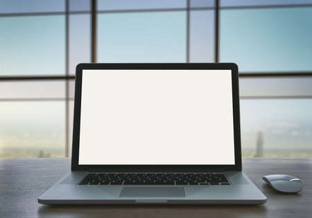 Laptop with blank screen on table in office