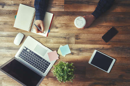 man sitting at his workplace in the office. top view close-up.の写真素材