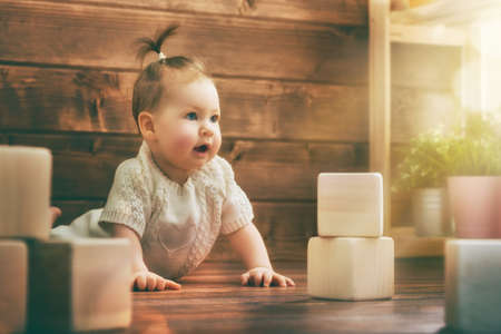 Happy child baby girl playing with blocks and having fun.の写真素材