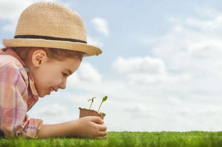 Cute little child girl planting seedlings. Fun little gardener. Spring concept, nature and care.の写真素材