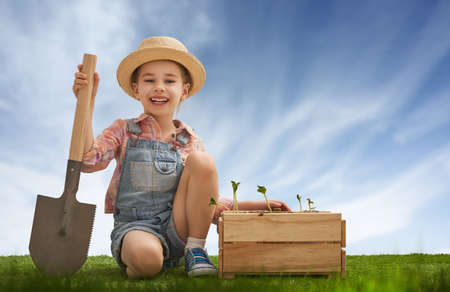 Cute little child girl planting seedlings. Fun little gardener. Spring concept, nature and care.の写真素材
