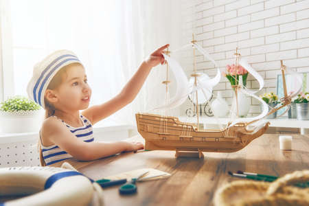 Child girl making model ship. Dreams of sea, adventures and travel.の写真素材