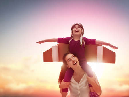 Mother and her child playing together. Little child girl plays astronaut. Child in an astronaut...