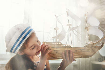 Child girl making model ship. Dreams of sea, adventures and travel.の写真素材