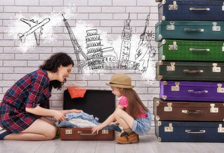 happy family preparing to vacation. mother and her child daughter packing their bags.の写真素材