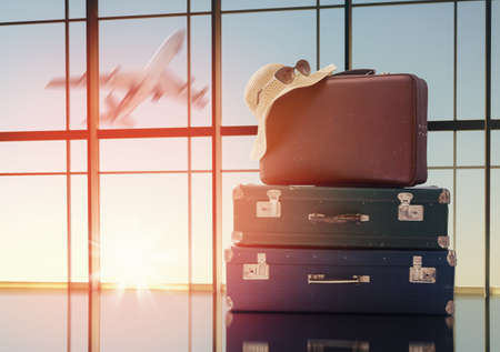 the concept of travel and holiday. suitcases against the window and the sunsetsの写真素材