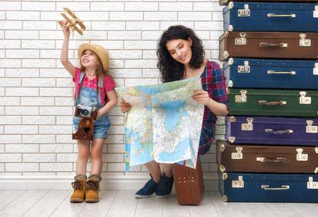 happy family preparing for the journey. mother and daughter looking at a map and choose a country to travel.の写真素材
