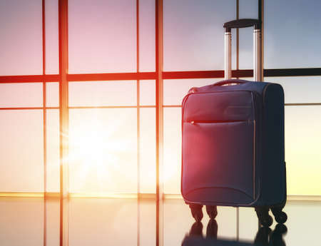the concept of travel and holiday. suitcase against the window and the sunsets
