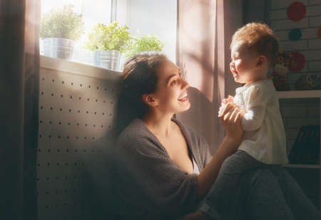 happy loving family. mother playing with her baby in the bedroom.