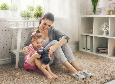 Happy loving family. Mother and her daughter child girl playing and making photo.の写真素材