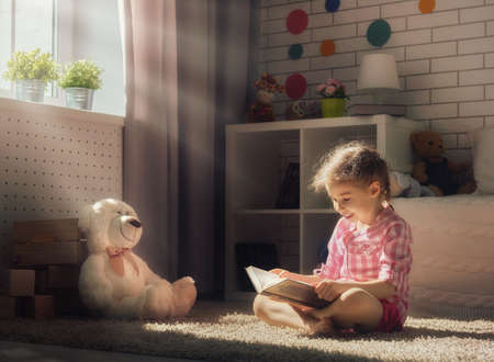 Cute little child girl reading a book.の写真素材