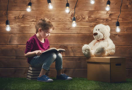 Cute little child girl reading a book.の写真素材