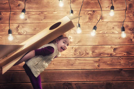 Child girl with toy rocket playing and dreaming of becoming a spacemen.の写真素材