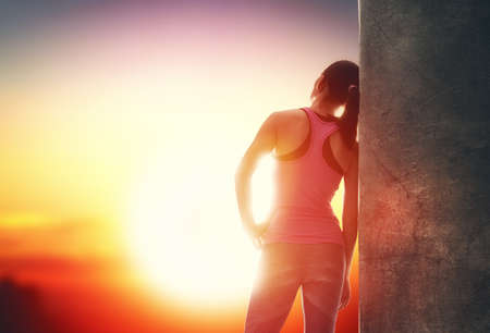 Athletic young woman running in the nature. Girl resting after an active fitness training. Healthy lifestyle.の写真素材