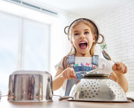 cute little child girl playing with utensils.の写真素材