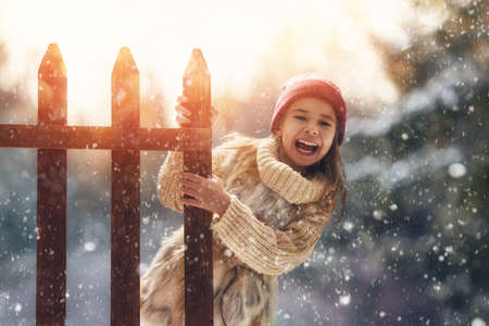 Happy child girl playing on a winter walk in natureの写真素材